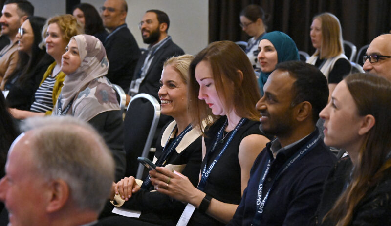 Close up of members of an audience attending a conference