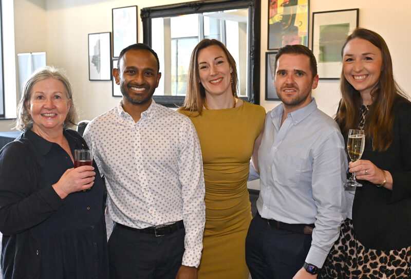 Five people standing side to side and smiling at the camera
